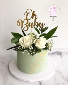 there is a cake with flowers on it and the words oh baby spelled in gold