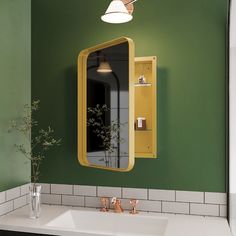 a bathroom with green walls and white tile on the floor, along with a yellow medicine cabinet