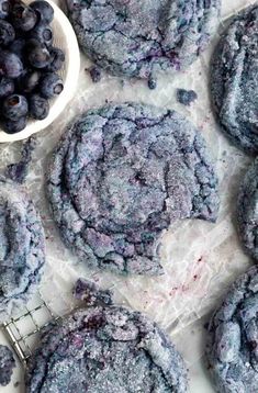 blueberry cookies with powdered sugar on top and bowl of berries next to them