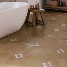 a bath tub sitting on top of a tiled floor next to a wooden table and shelf