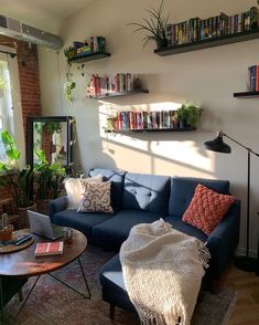 a living room filled with furniture and lots of books on the shelves next to a window