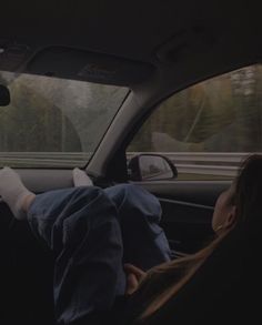 two people sitting in the back seat of a car with their feet on the dashboard