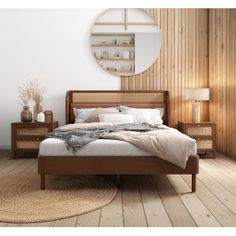 a bed sitting in a bedroom next to a wooden dresser under a round mirror on top of a wall