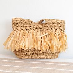 In Stock Now Shipping From Los Angeles The Elena Handbags Large Straw Woven Tote Bag with Tassles is an exquisite accessory ideal for adding a bit of timeless elegance to any occasion. The intricate weaving of the straw provides a stunning textural contrast and the lovely tassels add a touch of sophistication, making it perfect for formal or casual events. Crafted with the utmost attention to detail and quality, this bag is sure to be a treasured favorite for many seasons to come. Please note th Chic Straw Beach Bag With Tassels, Chic Beach Straw Bag With Tassels, Chic Tassel Straw Beach Bag, Beige Straw Bag With Tassels For Travel, Summer Bags With Fringe In Natural Color, Chic Vacation Bags With Tassels, Summer Fringe Bags In Natural Color, Summer Fringe Bag In Natural Color, Natural Color Bags With Tassels For Vacation