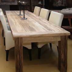 a wooden table with white chairs around it