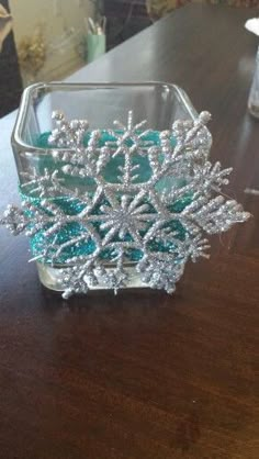 a glass container with snowflakes in it sitting on a table