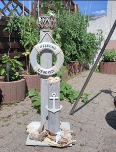 a wooden pole with an anchor and welcome sign on it