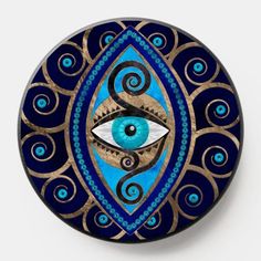 an eye painted on top of a blue and gold plate