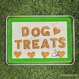 there is a sign that says dog treats on the grass