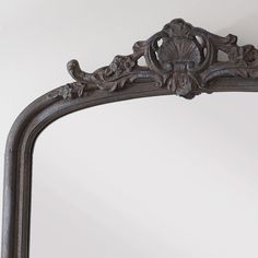 an ornate mirror hanging on the wall above it's head and bottom edge,