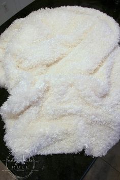 a pile of white fluffy material on top of a black countertop next to a tile floor