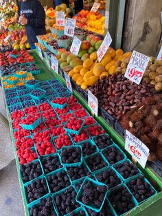 various fruits and vegetables are on display at the farmers'market, including raspberries