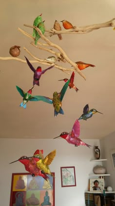 several colorful birds are flying in the air above a living room table and couches