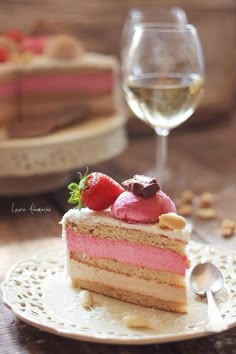 a piece of cake on a plate next to a glass of wine