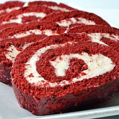 red velvet cake rolls with white icing on a plate