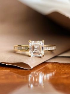 an engagement ring on top of a piece of paper