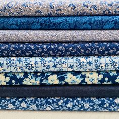 a stack of blue and white floral fabrics