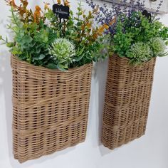 two wicker baskets with plants in them hanging on the wall next to each other