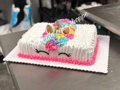 a decorated cake sitting on top of a metal counter next to a sign that says hope