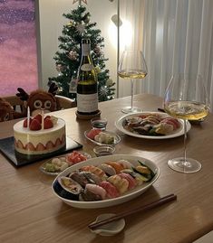 a table topped with plates of food next to a bottle of wine and two glasses