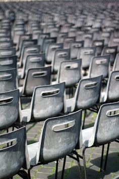 rows of empty chairs sitting in an empty stadium