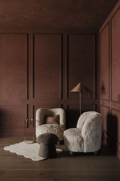 two chairs and a lamp in a room with wood paneling on the walls,