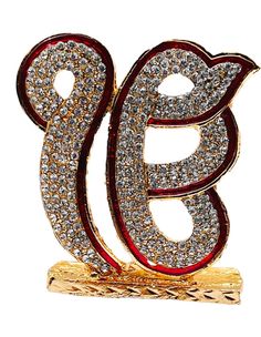 a gold and red brooch with the letter b on it's side, surrounded by diamonds