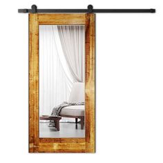 a mirror sitting on top of a wooden floor next to a window with curtains over it