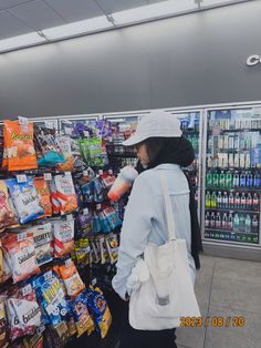 a woman is standing in front of a grocery store with her back to the camera