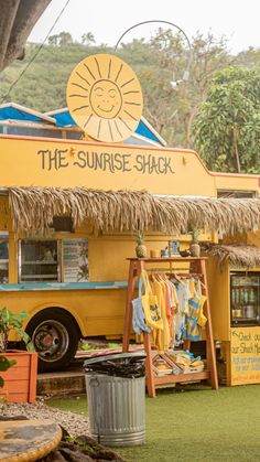 a yellow food truck parked on top of a lush green field