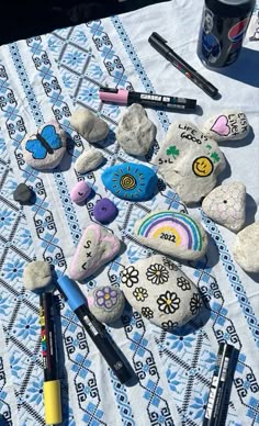 some rocks and markers are laying on a table with a blue towel next to them