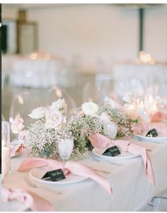 the table is set with white and pink flowers