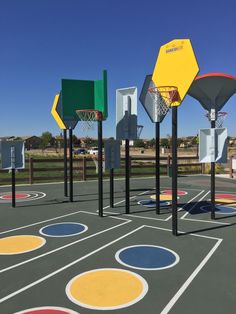 an outdoor basketball court with several different colors and shapes on the surface, including hexagonal hoops