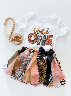 Adorable wild one first birthday party outfit.  Bodysuit with cute wild one design printed on the front.  Adorable coordinating handmade tutu with matching fabrics, ribbons and trim, ribbon bow at waist on sewn elastic band for flexible comfort. She's A Wild One Birthday Party, Shes A Wild One Birthday, Wild 1 Birthday Party, Wild 1 Birthday, 1 Birthday Party, Safari Theme Birthday Party, Wild One 1st Birthday, Wild Birthday Party, Birthday Party Outfit