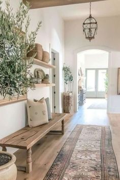 an entry way with a bench, potted plant and rug on the floor in front of it