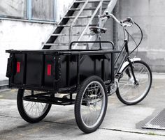 a bike with a trailer attached to it parked next to a stair case