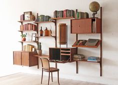 a bookshelf filled with lots of books next to a wall mounted book shelf