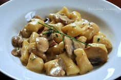 a white plate topped with pasta and mushrooms