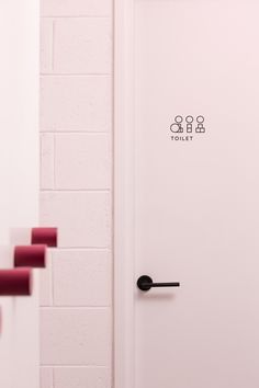 an open door in a bathroom with pink walls and red steps leading up to it