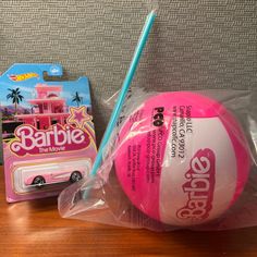 a pink ball and blue toothbrush sitting on top of a table next to each other