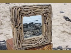 a mirror made out of driftwood on the beach