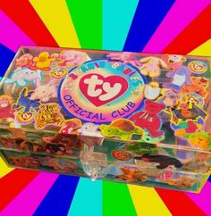 a colorful box filled with lots of stickers on top of a rainbow striped background