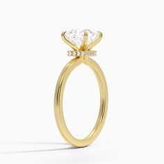 a yellow gold engagement ring with a single diamond in the center and side stones on each side