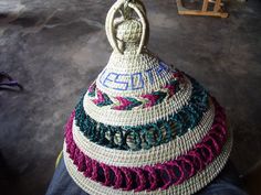 a person is holding a woven basket in their hand and it looks like they are making something out of yarn