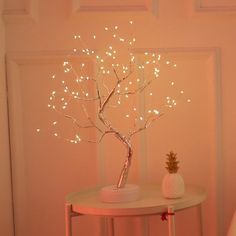 a table with a pineapple on it and a light up tree next to it