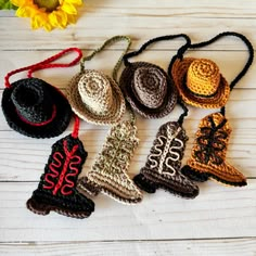 crocheted christmas ornaments are arranged on a white wooden surface next to a sunflower