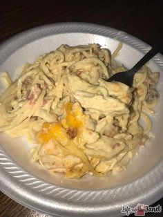 a white plate topped with pasta and meat