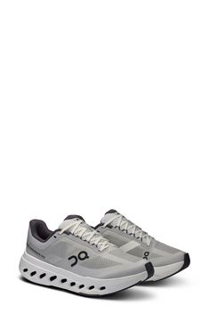 a pair of grey sneakers with black and white accents on the upper part of the shoe