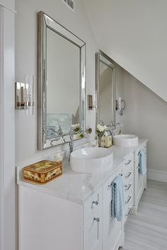 a white bathroom with two sinks and mirrors