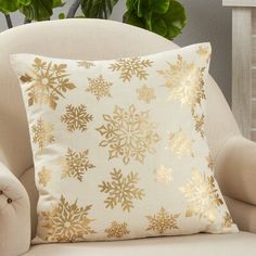 a white chair with a gold snowflake pillow on it